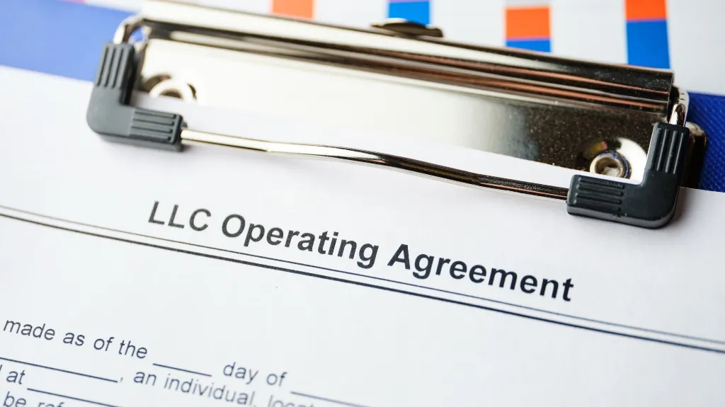 Close-up image of an LLC Operating Agreement document on a blue clipboard.